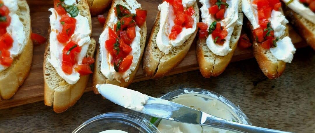 Kleine bruschetta met ricotta en verse tomaat topping.