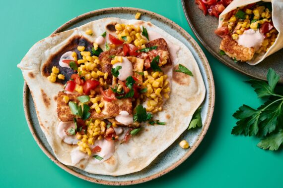 Berloumi kaas op een tortilla met tomaat, mais en verse kruiden, perfect voor een smakelijk recept.