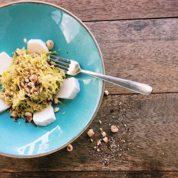 Verse kaas en spruitjes salade op blauwe schaal.