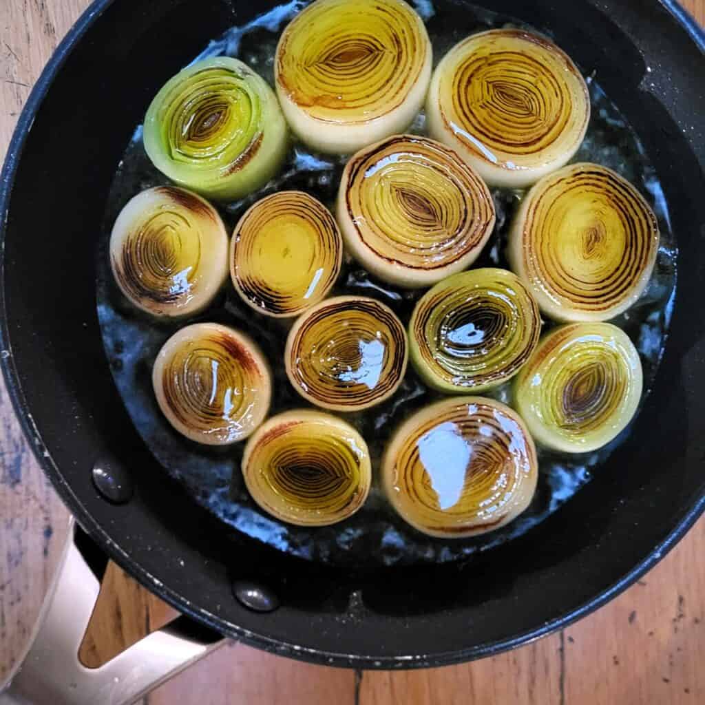 Gekonfijte prei en fenegriek in een pan, klaar voor serveren.