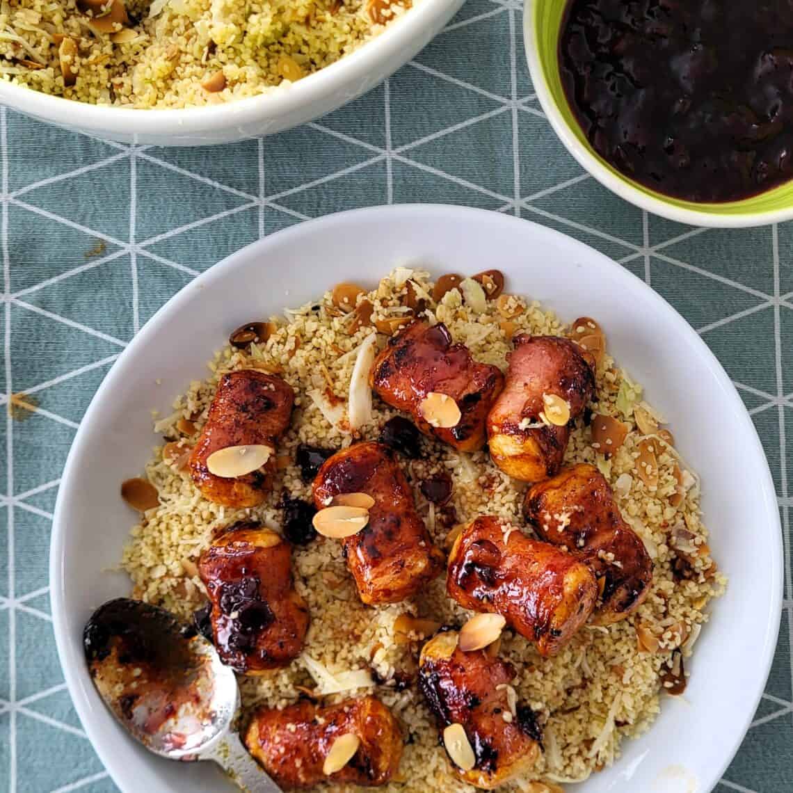 Berloumi bacon bites geserveerd op een bord met couscous en saus.