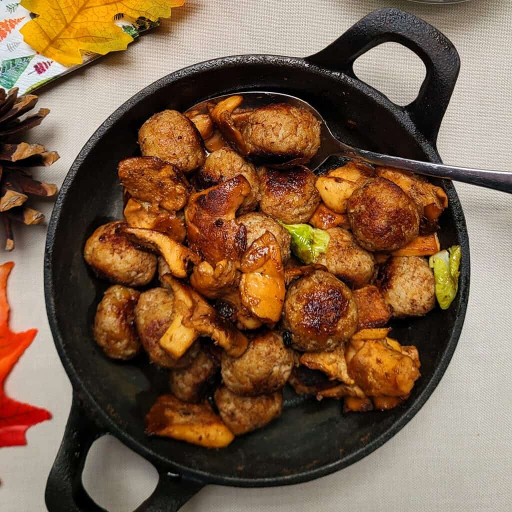Kaasballetjes met champignons en groenten in een gietijzeren pan.