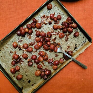 Geroosterde druiven op een bakplaat met labneh en balsamico.