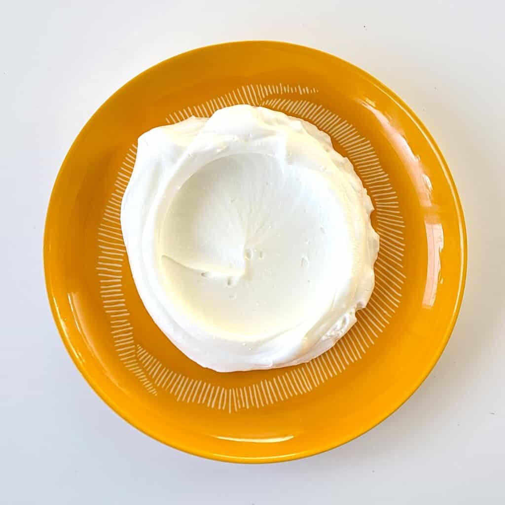 Gekonfijte paprika in een oranje kom, klaar voor gebruik.