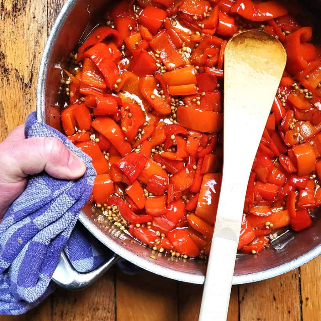 Gekonfijte paprika in een pan, klaar voor gebruik in recepten of als smaakmaker.